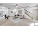 Bright living room featuring plush carpet, a staircase, and refined decor, perfect for relaxing and entertaining at 891 Channel Dr, Lawrenceville, GA 30046