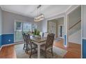 Elegant dining room with a modern light fixture, hardwood floors, and wainscoting at 1663 Willow Way, Woodstock, GA 30188