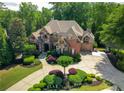 A bird's eye view of the brick and stone house with circular driveway and manicured front yard at 8340 Colonial Pl, Duluth, GA 30097