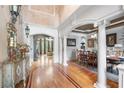 Elegant foyer with hardwood floors, decorative columns, and views into the dining and living areas at 8340 Colonial Pl, Duluth, GA 30097