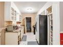Galley kitchen featuring white cabinets, exposed brick accents, and tiled floor at 2054 Fargo Se Pl, Atlanta, GA 30316