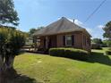 Charming single-story brick home with a manicured lawn, mature landscaping, and covered carport at 871 Malcom Se St, Conyers, GA 30012