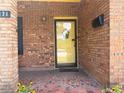 Close-up of brick front porch with tiled flooring, yellow door, and manicured landscaping at 871 Malcom Se St, Conyers, GA 30012