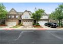 View of townhomes featuring landscaped lawns and two-car garages, complemented by a well-maintained street at 1630 Marsanne Nw Ter # 27, Kennesaw, GA 30152