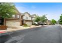 Street view of townhomes with two-car garages and well-kept lawns, set against a bright sky at 1630 Marsanne Nw Ter # 27, Kennesaw, GA 30152