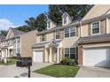 Attractive townhome featuring a manicured lawn, attached garage, and traditional architectural details at 4139 Magnolia Glen Walk, Norcross, GA 30093