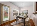 Bright dining room with a modern chandelier, a dining table set for four, and a door leading to the backyard at 867 Crested Hawk Trl, Sugar Hill, GA 30518