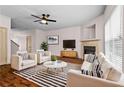 Bright living room features a fireplace, modern furniture, and abundant natural light with windows and door to other rooms at 867 Crested Hawk Trl, Sugar Hill, GA 30518