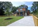 Beautiful three-story home with a spacious driveway, lush green lawn, and contemporary wood and gray exterior at 1197 Avondale Se Ave, Atlanta, GA 30312