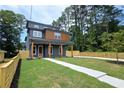 Three-story home boasts a manicured lawn, charming front porch, and a contemporary wood and grey design at 1197 Avondale Se Ave, Atlanta, GA 30312
