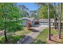 A neatly kept home with a detached garage and a long driveway lined with mature trees at 1280 Sherry Dr, Alpharetta, GA 30009