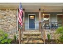 Inviting front porch with stone steps, charming decor, and an American flag at 1280 Sherry Dr, Alpharetta, GA 30009