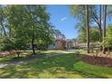 Landscaped front yard with a long driveway leading to a charming home and detached two-car garage at 1280 Sherry Dr, Alpharetta, GA 30009