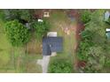 Aerial view of a single-Gathering home with a dark roof, a sprawling green yard, and mature trees at 1959 Christian Circle, Conyers, GA 30013