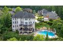 Expansive backyard with a luxurious pool, spa, multiple decks, and lush landscaping at 212 Fernwood Pl, Woodstock, GA 30188