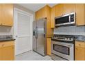 Kitchen featuring stainless steel appliances, wooden cabinetry, granite countertops, and a white tile backsplash at 3338 Peachtree Rd # Apt 403, Atlanta, GA 30326
