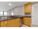 Well-lit kitchen featuring granite countertops, stainless steel appliances, and light wood cabinets in this home at 3338 Peachtree Rd # Apt 403, Atlanta, GA 30326