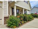 View of the home's exterior showing lush landscaping with flowering shrubs, flowers and sidewalk to front door at 4024 Broadmoor Sw Ct, Austell, GA 30106