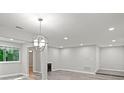 Open living room with gray wood-look flooring, recessed lighting, and a modern light fixture, perfect for entertaining at 12 Dunwoody Springs Dr # 12, Atlanta, GA 30328