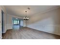 Inviting dining room boasts modern gray vinyl flooring, wainscoting and decorative lighting at 4706 Derby Loop, Fairburn, GA 30213