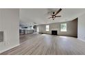 Open-concept living room with fireplace, stainless steel appliances, and gray vinyl flooring at 4706 Derby Loop, Fairburn, GA 30213