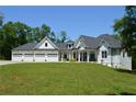 Charming home featuring a three-car garage, manicured lawn, and long driveway at 8 Ripplewood Trl, Euharlee, GA 30145