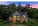 Twilight view of brick home with manicured lawn and lush trees at 1200 Bay Pointe Terr Ter, Alpharetta, GA 30005