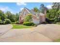 Brick home with large driveway, attached garage, and lush landscaping at 1200 Bay Pointe Terr Ter, Alpharetta, GA 30005