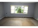 Empty living room featuring neutral paint, a large window, and worn carpet flooring at 2172 Jernigan Drive Se, Atlanta, GA 30315