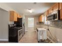 Galley kitchen with stainless steel appliances and light wood cabinets, ready for renovation at 1013 Odelle Cir, Mcdonough, GA 30253