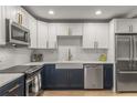 Updated kitchen features stainless appliances, farmhouse sink, subway tile backsplash, and contrasting navy cabinets at 1105 Clairemont Ave # O, Decatur, GA 30030
