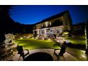 Nighttime view of a beautifully landscaped backyard with patio, seating area, and manicured lawn at 336 Parc Xing, Acworth, GA 30102