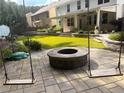 Backyard featuring a stone patio with a fire pit and mature landscaping at 336 Parc Xing, Acworth, GA 30102