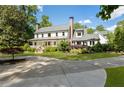 Attractive two-story home with a covered front porch, enhanced by mature trees and manicured greenery at 11355 Bowen Rd, Roswell, GA 30075