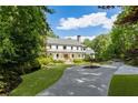 Charming two-story home with a welcoming front porch and lush landscaping, set back from the street at 11355 Bowen Rd, Roswell, GA 30075