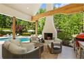 Inviting covered patio featuring a cozy fireplace, comfortable seating, and a view of the pool at 11355 Bowen Rd, Roswell, GA 30075