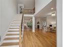 Bright living room with staircase, wood floors, two-story ceiling, and a view to dining area at 4735 Cambridge Trce, Atlanta, GA 30338