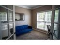 Cozy office space with a large window, blue sofa, neutral walls, glass French doors, and plush carpet at 760 King Sword Ct, Mableton, GA 30126