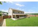 Spacious backyard features a large lawn, a screened-in porch, and a firepit area, perfect for outdoor entertaining at 149 Manor Ln, Woodstock, GA 30188