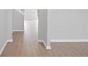 Bright hallway featuring modern light-colored wood flooring with a view of stairs and an entry at 3650 River Rock Rd, Lithonia, GA 30038