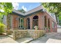 Beautiful brick home with a stone porch and arched entryway, featuring green trim and a well-manicured lawn at 1356 Emory Ne Rd, Atlanta, GA 30306