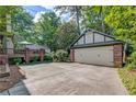 Detached two-car garage with brick accents, spacious driveway, and lush landscaping in the backyard at 1356 Emory Ne Rd, Atlanta, GA 30306