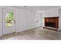 Open-concept living room with a brick fireplace and access to the front door at 2025 Oakley Se Trce, Smyrna, GA 30080