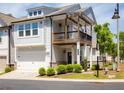 Two-story townhome showcases a balcony, an attached garage, and manicured landscaping at 360 Hayden Cir, Woodstock, GA 30189