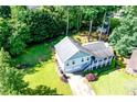 An aerial view shows the home's large yard, mature trees, and covered front porch at 850 Old Spring Way, Sugar Hill, GA 30518