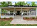 Inviting front porch with seating area, complemented by a lush, green lawn and landscaping at 550 Stewart Nw Ave, Marietta, GA 30064