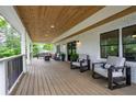Relaxing front porch with wood ceiling, railing, stylish seating, and white brick exterior for serene outdoor enjoyment at 550 Stewart Nw Ave, Marietta, GA 30064