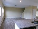 Bright living room with wood floors and a granite countertop island in kitchen at 2197 Boxwood Cir, Conyers, GA 30094