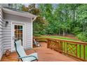 An inviting outdoor deck space with railing and seating, overlooking a lush and well-maintained backyard lawn area at 3953 Lorien Nw Way, Kennesaw, GA 30152