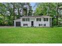 Traditional-style home with an expansive green lawn and attached garage at 1386 Pineglen Dr, Riverdale, GA 30296
